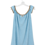 A light blue sleeveless top with ruffled trim and lace-up shoulder details, hanging on a clear plastic hanger against a white background.