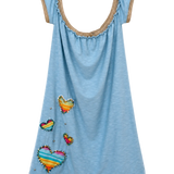 A light blue sleeveless tunic dress with a scoop neckline trimmed in tan lace, decorated with colorful striped fabric hearts and small silver rhinestones, shown against a plain white background.