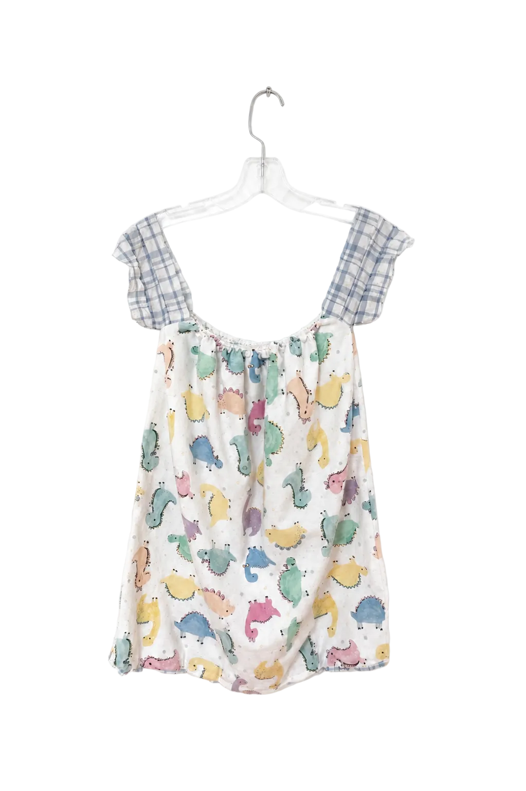 A children's sleeveless romper hanging on a clear plastic hanger against a plain white background. The romper has a white base with a colorful print of cartoon dinosaurs and has blue-and-white plaid shoulder straps.