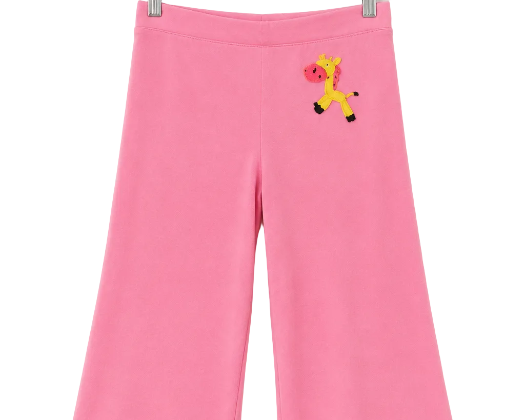 Pink wide-leg cropped pants for kids, hanging on a clear plastic hanger against a white background. The pants feature a small embroidered giraffe motif on the upper left hip.