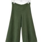 A pair of olive green wide-leg cropped pants hanging from a clear plastic hanger against a plain white wall.