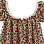 A close-up of a floral off-the-shoulder top with ruffled sleeves, a white lace neckline, and a small decorative button at the center, shown against a plain light background.
