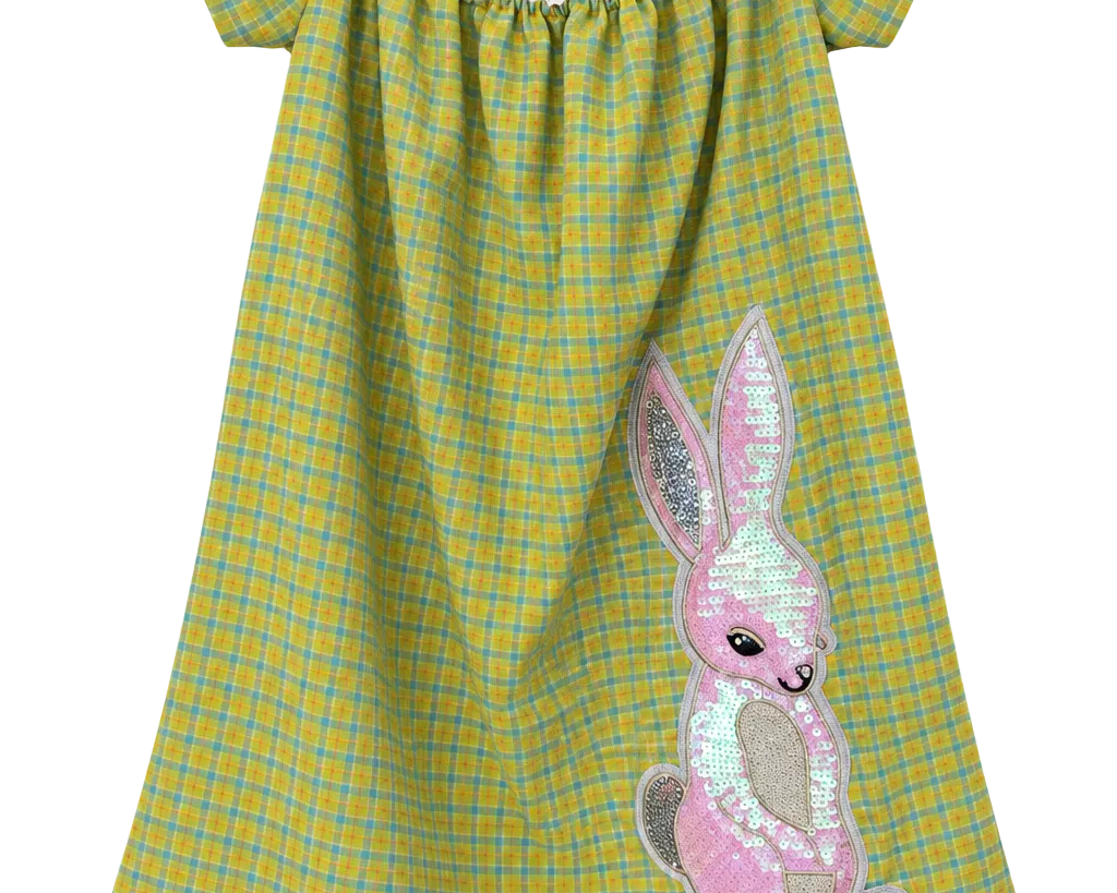 A yellow and green plaid off-the-shoulder nightgown with a pink sequined bunny applique on the front and a ruffled light blue hem.