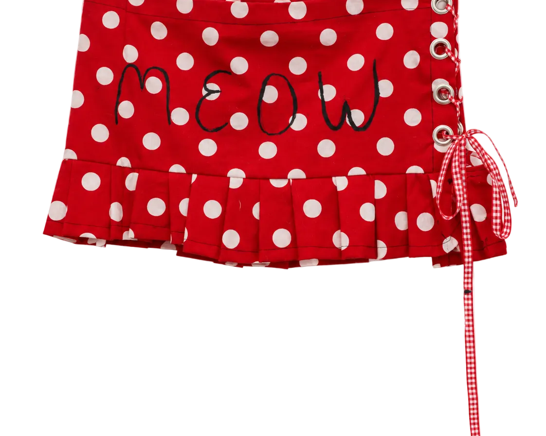 Red and white polka dot skirt with 'MEOW' embroidered on the front, featuring a ruffled hem, side lace-up closure with metal eyelets, and a red-and-white gingham ribbon tie.