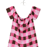 A pink and brown checkered short-sleeve top with a smocked neckline, hanging on a clear plastic hanger against a plain white background.