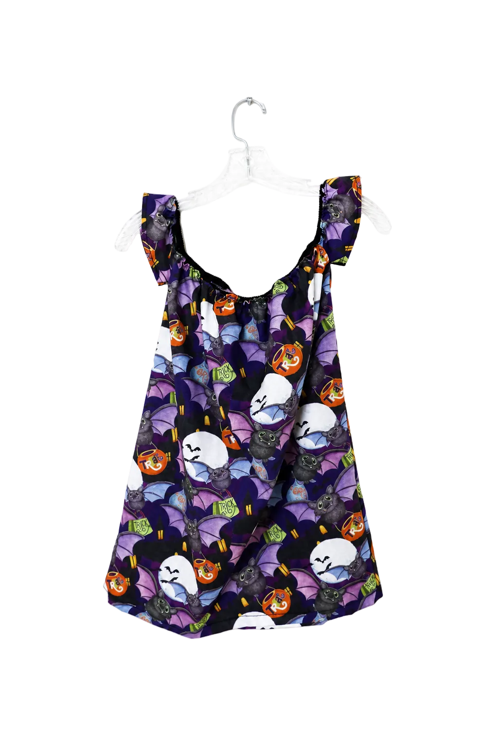 A sleeveless baby/toddler dress with ruffled shoulder straps, featuring a purple and black Halloween print of bats, ghosts, and jack-o'-lanterns, hanging on a white plastic hanger against a white background.